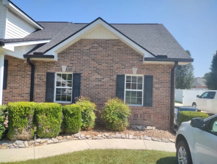 Brick home gutter installation with black drip edge